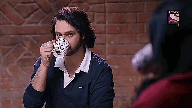 a man is drinking from a cup with a sony logo on the bottom