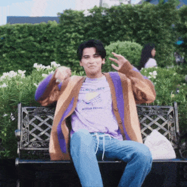 a man sitting on a bench wearing a purple shirt that says lunchable butter toast