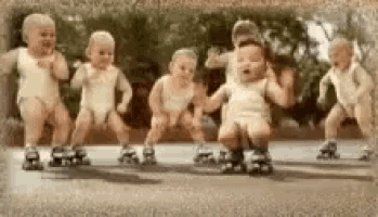 a group of babies are dancing and rollerblading on a street .