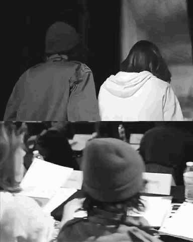 a man and a woman are sitting at a table in a black and white photo