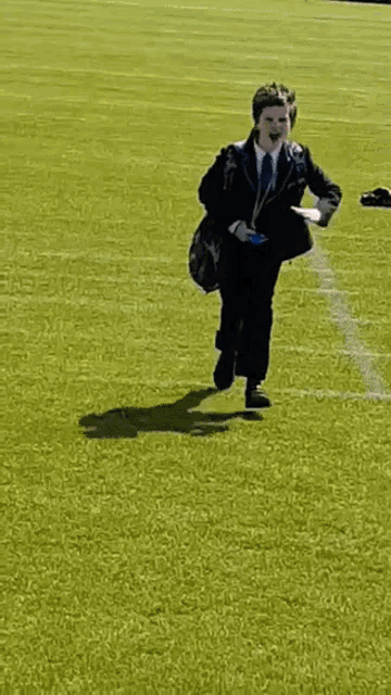 a man in a suit is running through a field