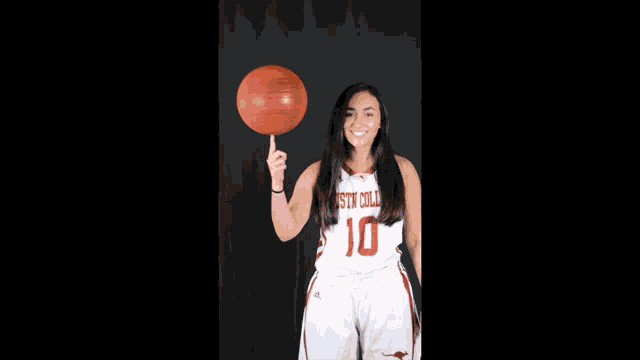 a woman holding a basketball with the number 10 on her shirt