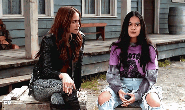 two women sit on a porch one wearing a purple shirt that says oto