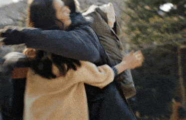 a man and a woman hugging each other in a blurry photo