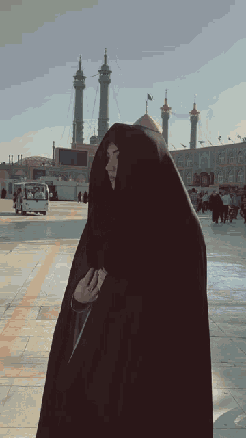 a woman in a black veil is standing in front of a building