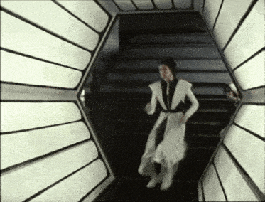 a woman in a white dress is running down the stairs