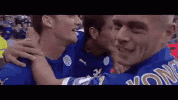 a group of soccer players are hugging each other in a stadium