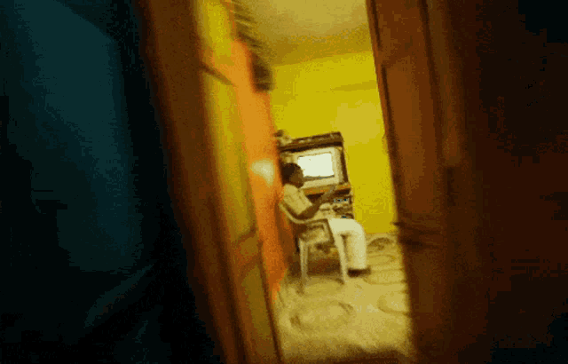 a man sits in a chair in front of a television