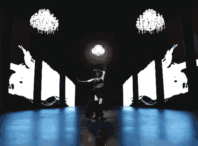 a silhouette of a woman holding a chandelier in front of a wall that says ' est ' on it
