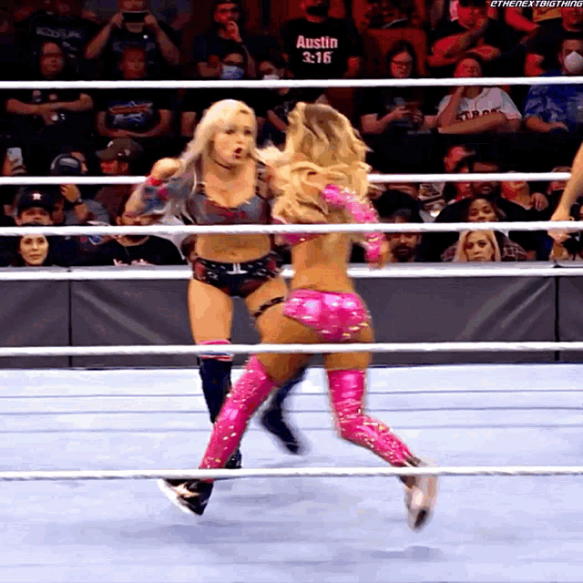 two women wrestling in a ring with a shirt that says austin on it