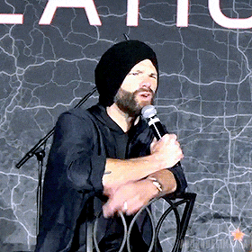 a man wearing a black hat is holding a microphone