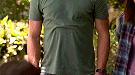 a man in a green shirt is standing next to a woman
