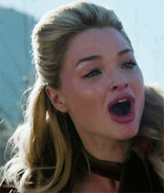 a close up of a woman 's face with her mouth wide open