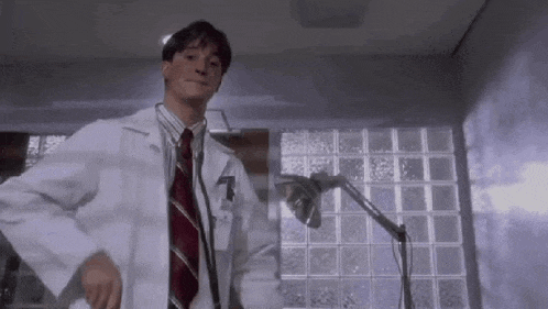 a man in a lab coat and tie is using a stethoscope in a room .
