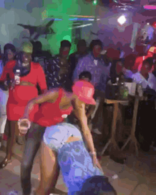 a group of people are dancing in a room with a lot of lights .