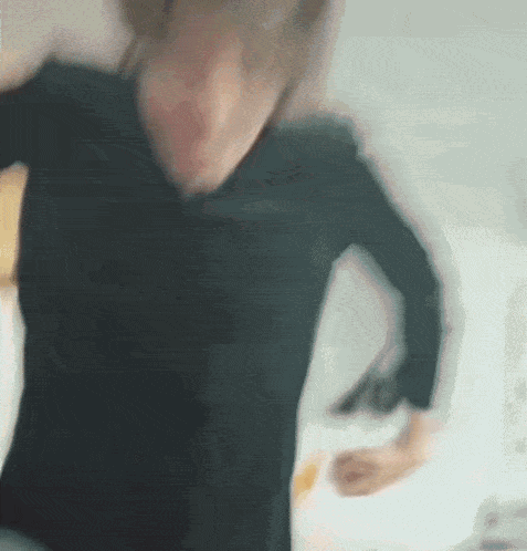 a blurry picture of a woman in a black shirt dancing