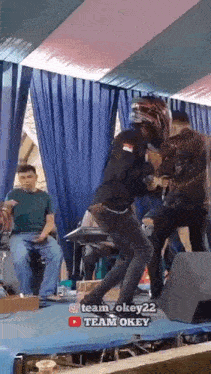 a man in a helmet is dancing on a stage in front of a group of people .