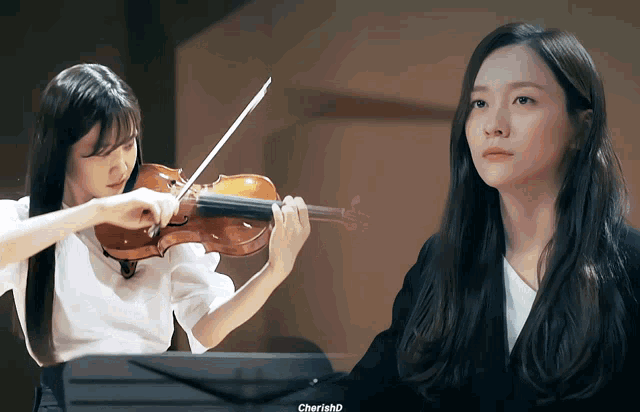 a woman playing a violin and another woman playing a piano