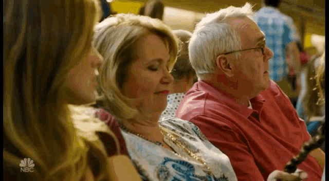 a group of people are sitting in a room with nbc written on the bottom