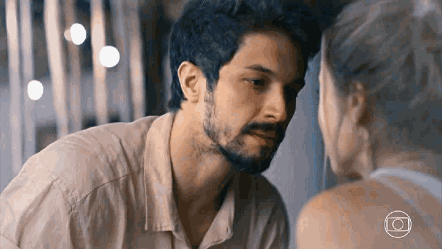 a man and a woman are looking at each other .
