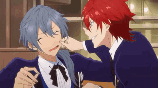 a man with red hair is putting his finger in another man 's ear .