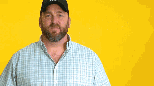 a man with his hands folded in front of a yellow background with the word thank written in white