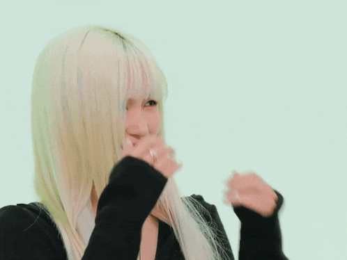 a woman with long blonde hair is wearing a black sweater and a black hat .