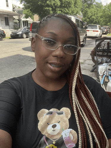 a woman wearing glasses and a black teddy bear shirt