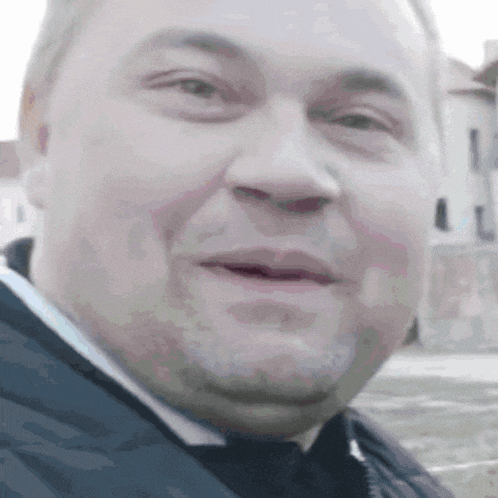 a close up of a man 's face with a slight smile on his face