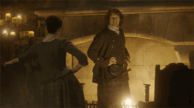 a man and a woman are standing in front of a fireplace and the man says you are a ridiculous human being