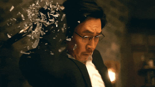 a man in a suit and glasses holds a sword
