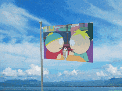 a colorful flag is flying in the wind in front of a body of water