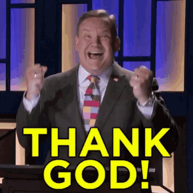 a man in a suit and tie stands at a podium with his fist in the air and says thank god