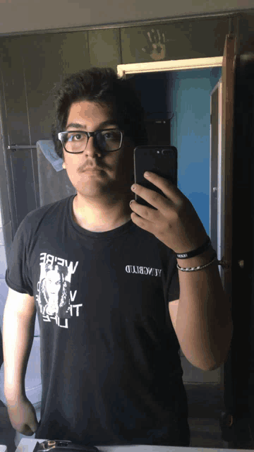 a man taking a selfie with a black shirt that says " brew " on the front