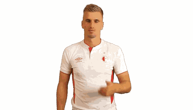 a man in a white and red umbro shirt covering his face with his hand