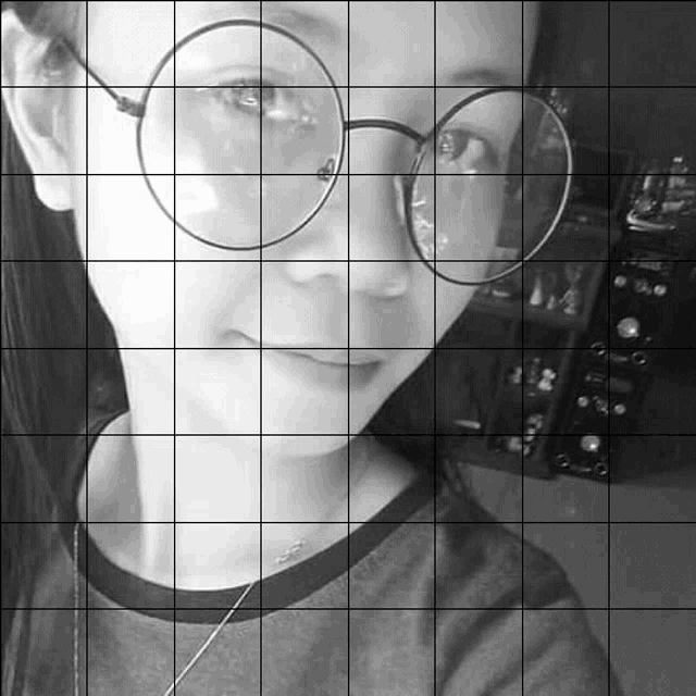 a black and white photo of a woman wearing round glasses .