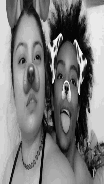a black and white photo of two girls wearing dog face masks
