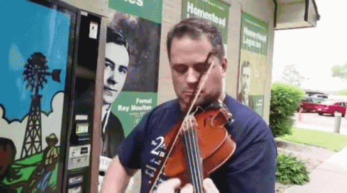 a man is playing a violin in front of a homestead sign