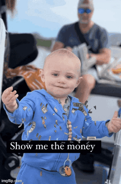 a baby wearing a blue outfit with money on it and the words show me the money