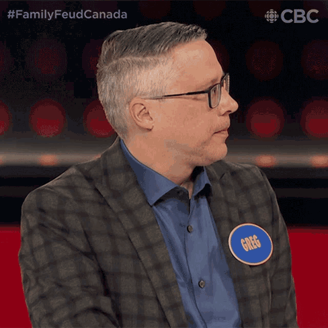 a man wearing glasses and a name tag that says greg