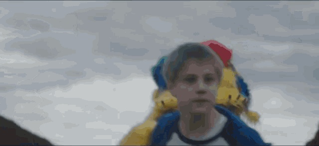 a young boy carrying a stuffed animal on his back