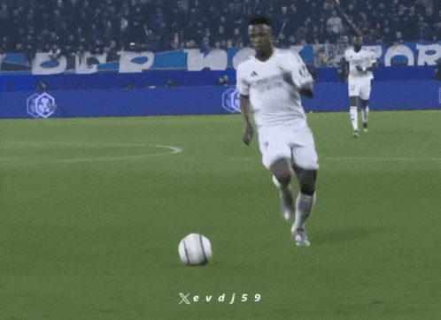 a soccer player is kicking a soccer ball on a field with a banner for crypto.com in the background
