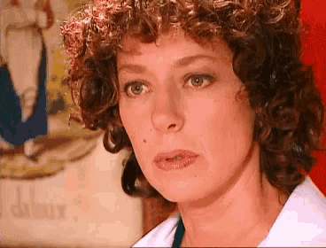 a close up of a woman 's face with a sign in the background that says ' a '