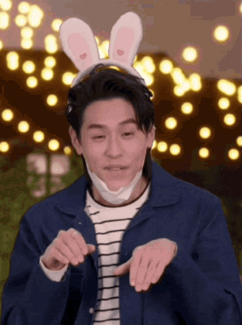 a man wearing bunny ears and a mask is making a face