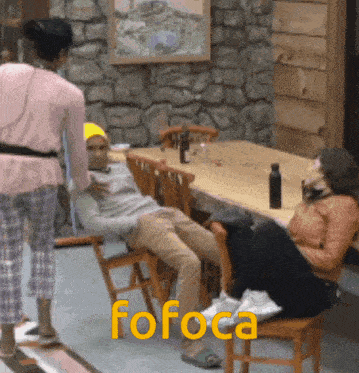 a woman standing next to a man sitting on a chair with the word fofoca written on the floor
