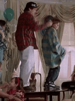 a man and a boy are dancing in a living room .