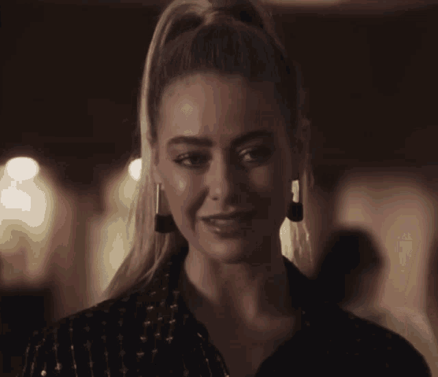 a close up of a woman 's face with a ponytail