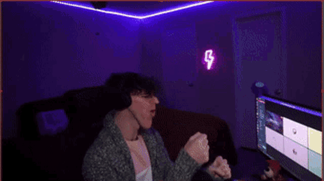 a man sitting in front of a computer with a lightning bolt on the wall