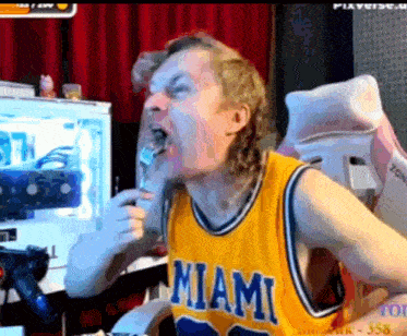 a man in a miami jersey is eating food