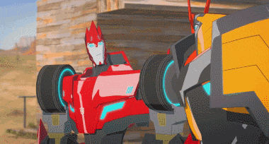 two transformers are standing next to each other in front of a brick building ..
